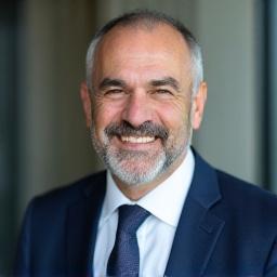 Άντρας με επαγγελματικό ντύσιμο χαμογελά, Πρόσωπο του Αλέξανδρου Παπαδόπουλου